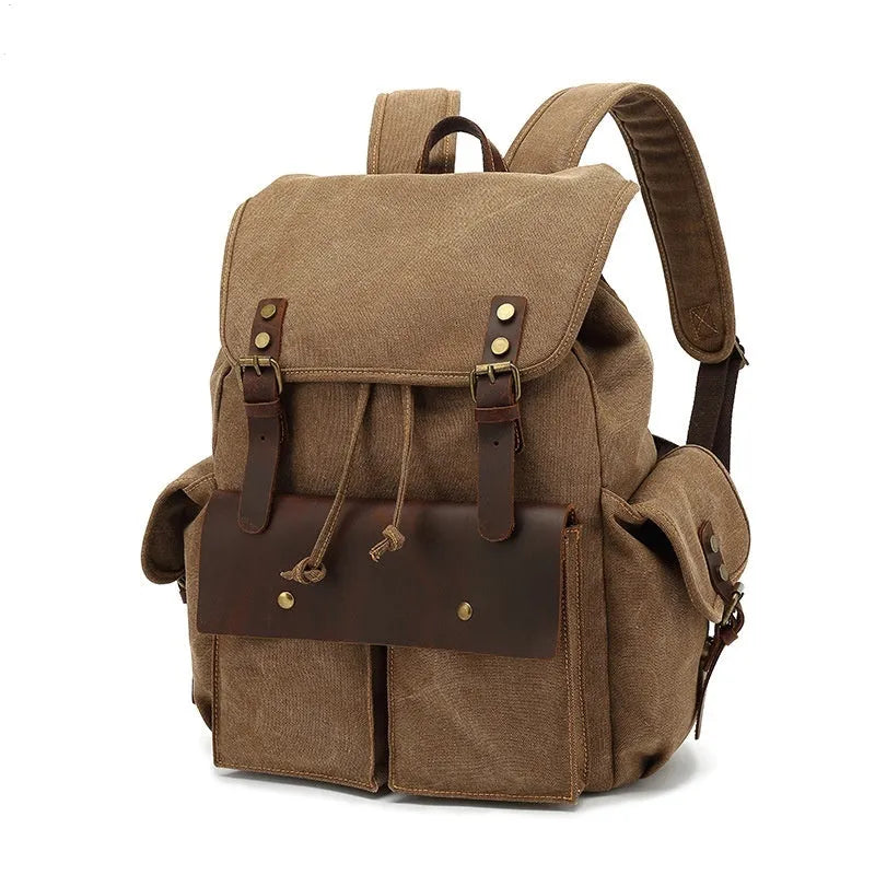 Retro military green canvas backpack with antique bronze hardware, shown with a laptop.