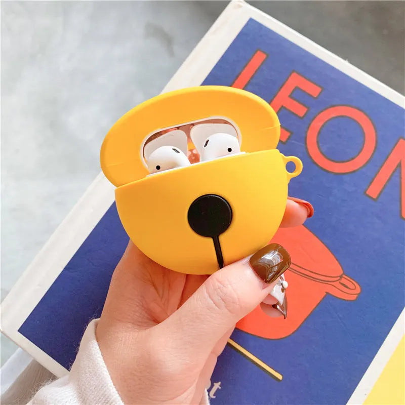 Yellow silicone protective case for AirPods with a small bell charm and a carry strap.