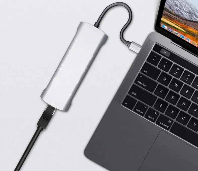 Grey aluminium USB-C docking station showing HDMI, VGA, USB 3.0, and USB-C PD charging ports.