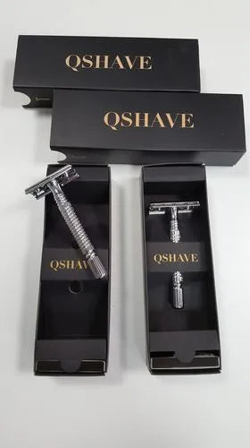 Double edged safety razor with chrome-plated brass handle and closed comb head on a storage box.