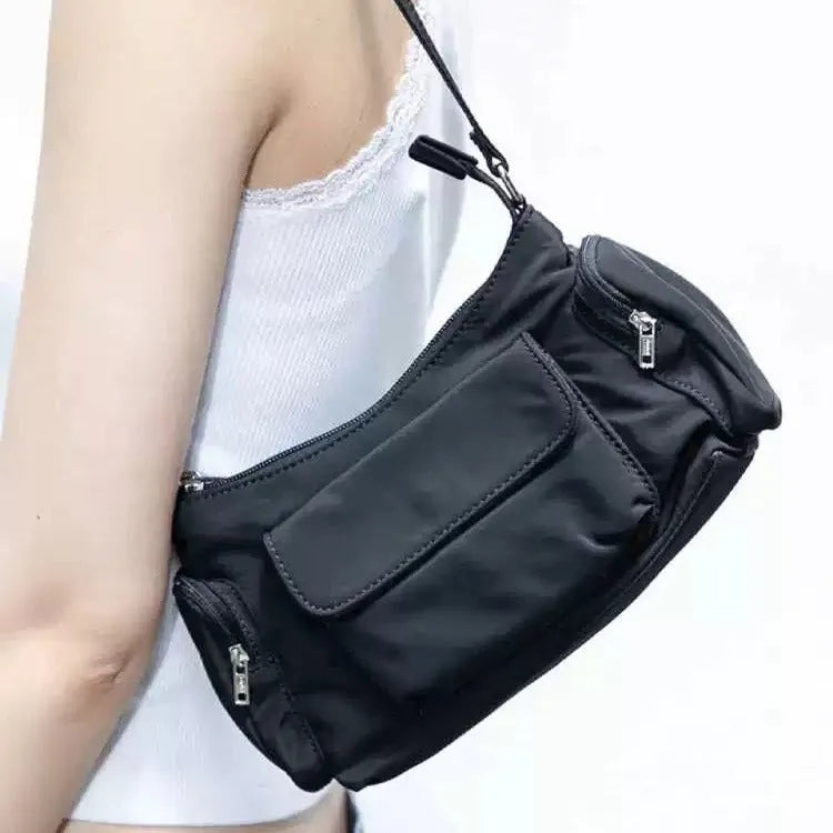 Black nylon lightweight shoulder bag with double pockets and side line detailing.