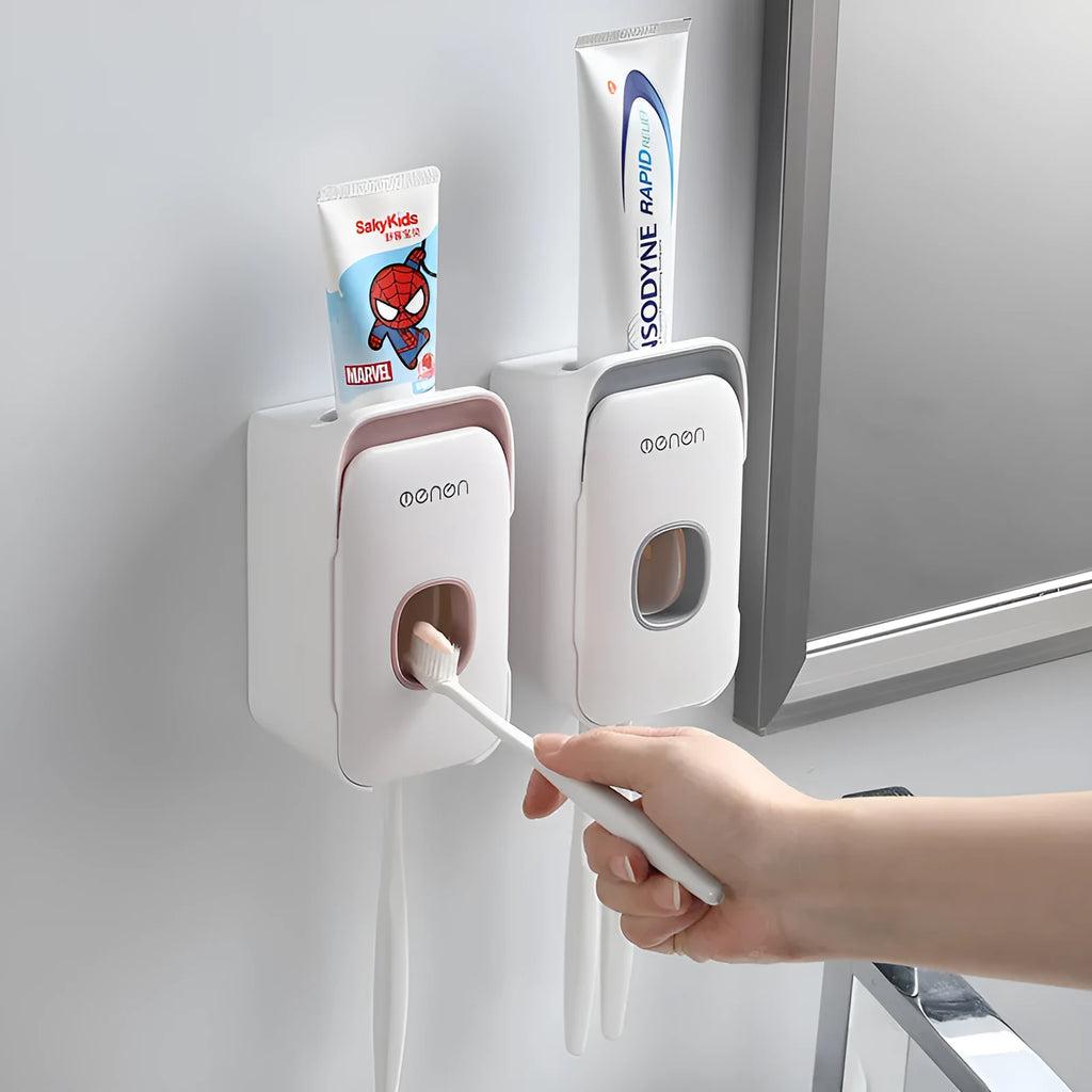 Automatic toothpaste dispenser unit mounted on a wall in a choice of blue, grey, or pink colours.