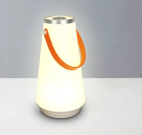 White rechargeable LED bedside lamp with adjustable brightness on a table.