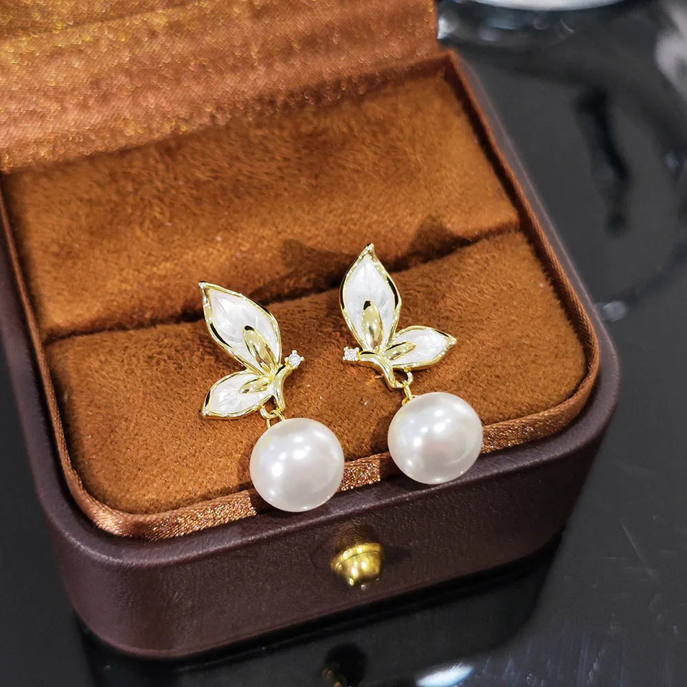 A pair of simple butterfly drop earrings for women with an electroplated finish on a copper base.