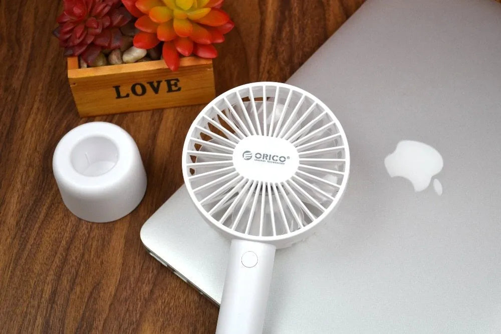 White ORICO FH1 portable USB rechargeable fan with fine line detailing, shown in handheld and desktop positions.