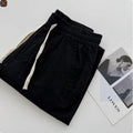 Men's loose straight leg casual trousers in beige with a drawstring waist and elasticated ankles.