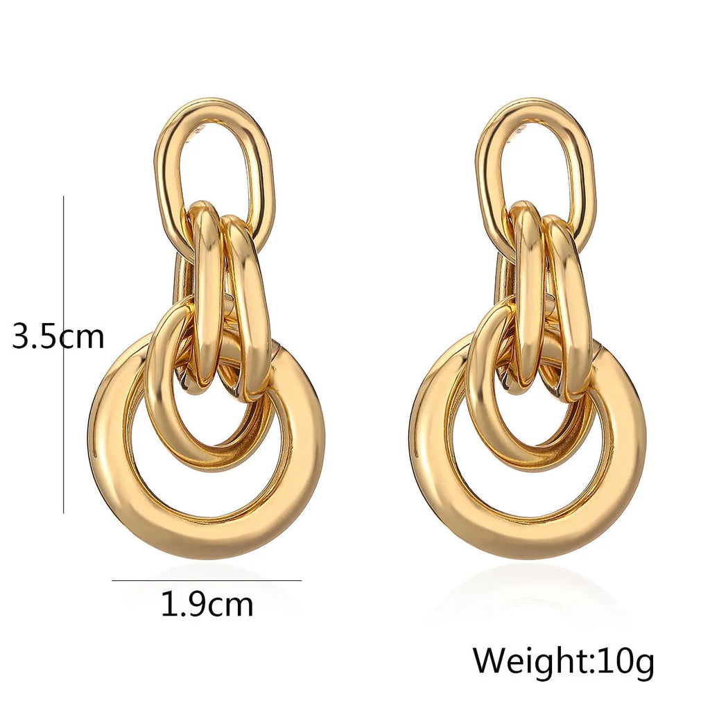 Gold geometric copper earrings with irregular asymmetric design on display
