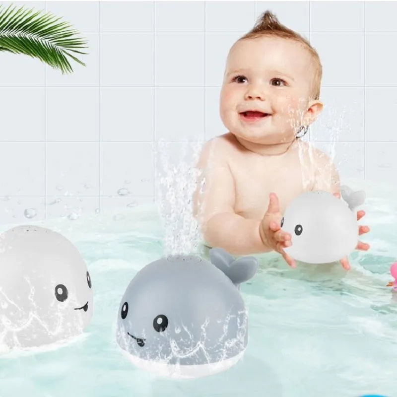 White and blue whale-shaped electric bath toy spraying water with coloured lights flashing