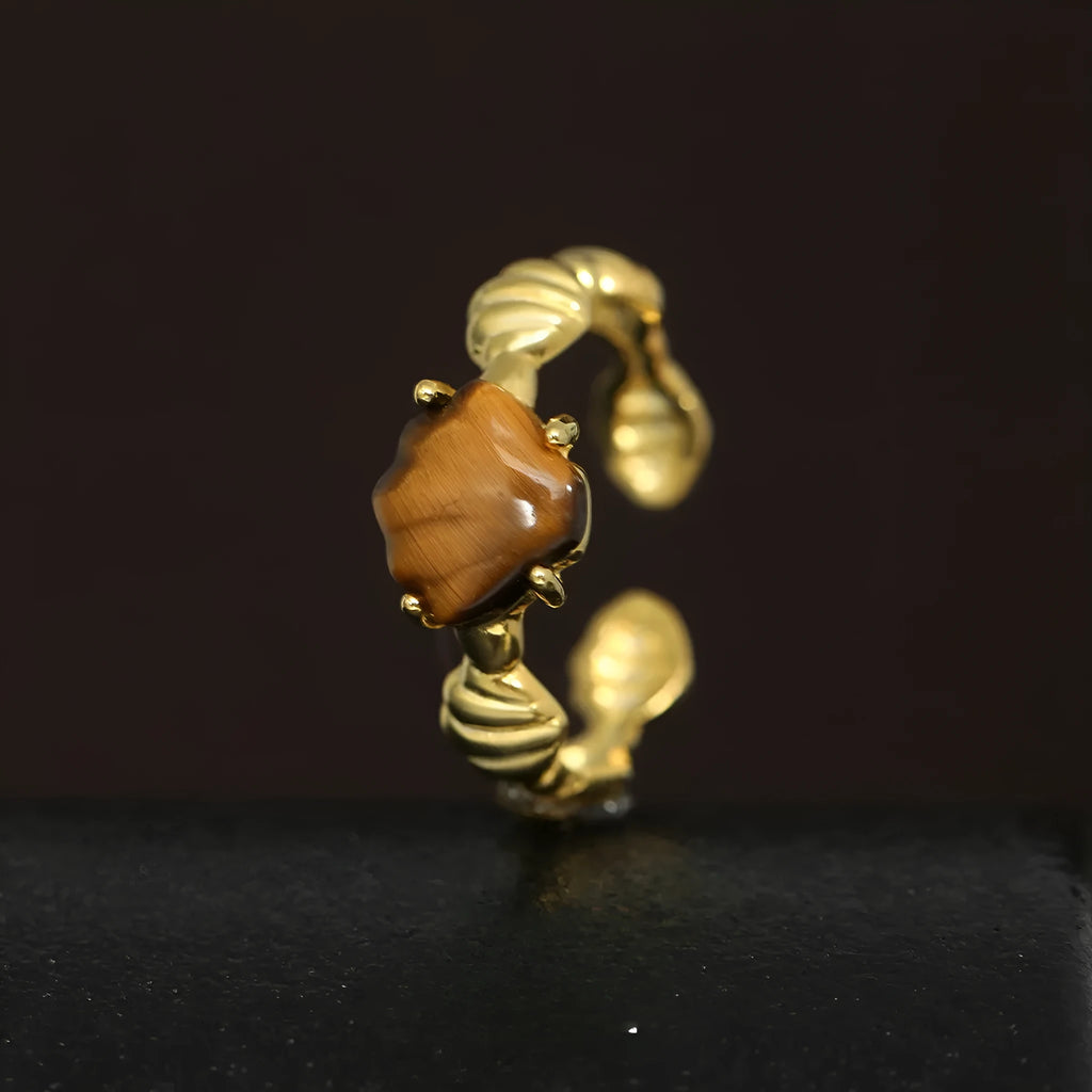 Women's sterling silver ring with shell element, tiger eye accents, and adjustable opening in gold electroplated finish