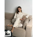 White floral print women's loungewear set with bell sleeve top and wide leg trousers.