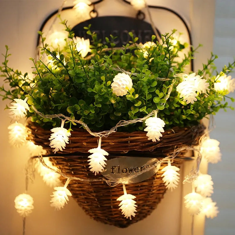 Battery powered LED pine cone light string in warm white colour with plastic shell construction