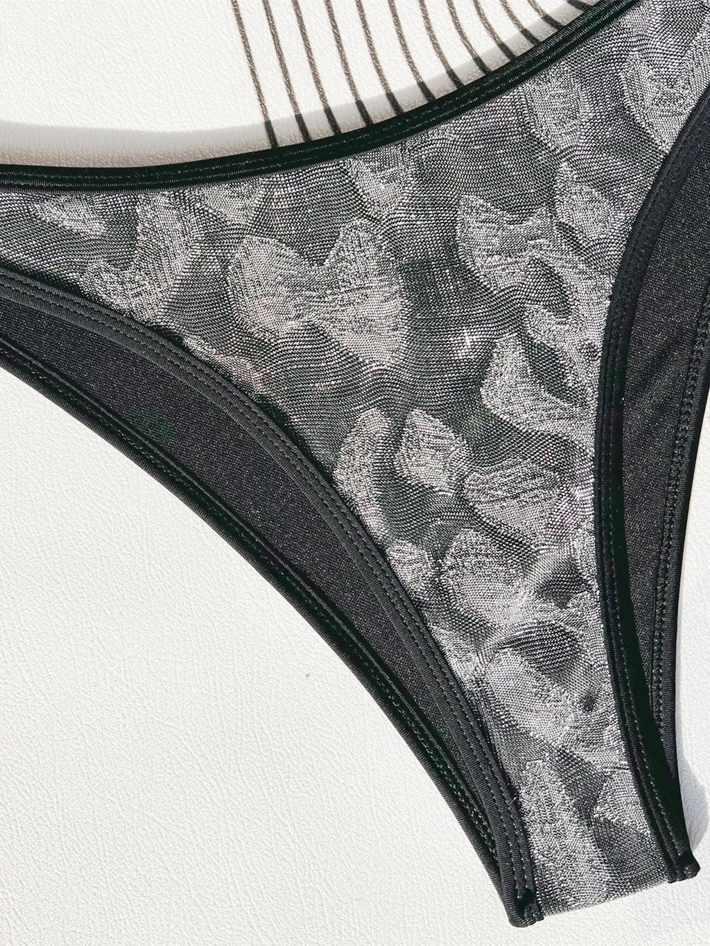 Black ladies bikini strap swimsuit on mannequin showing one-piece design