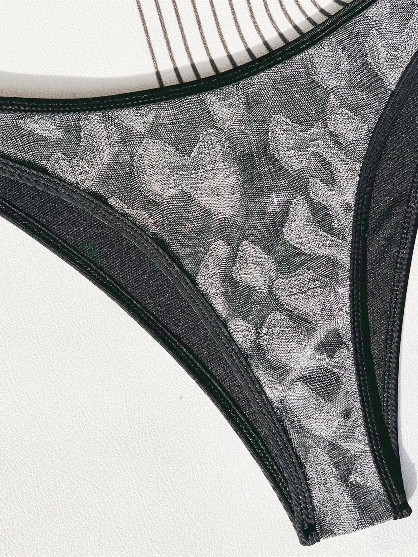 Black ladies bikini strap swimsuit on mannequin showing one-piece design