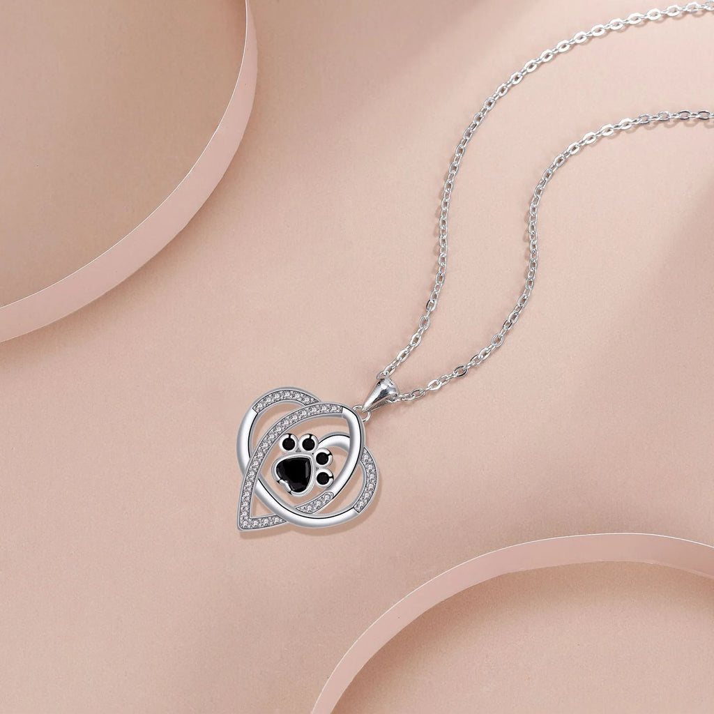 Copper necklace with dog paw and cat footprint pendant on a cross chain.