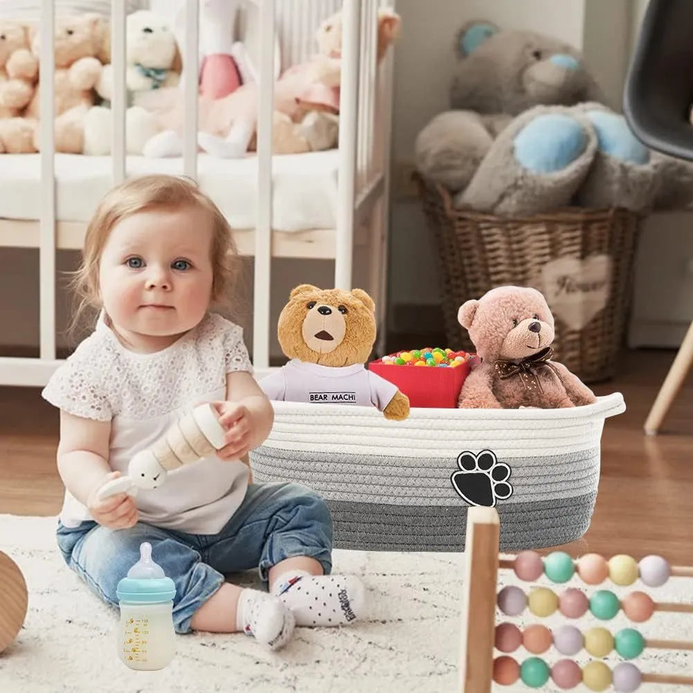 Small light beige hand-woven cotton rope storage basket with a wooden base and a handle.