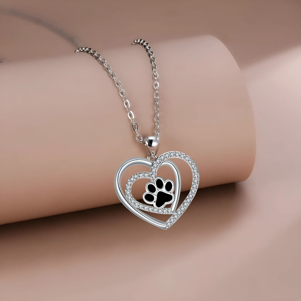 Women's necklace with a copper dog paw print heart pendant on a cross chain.