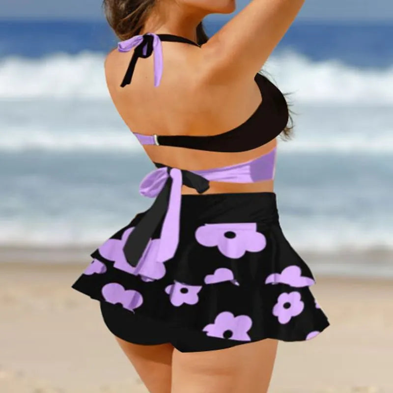 Women's purple two-piece swimsuit with separate skirt and lace-up details on high-waisted briefs