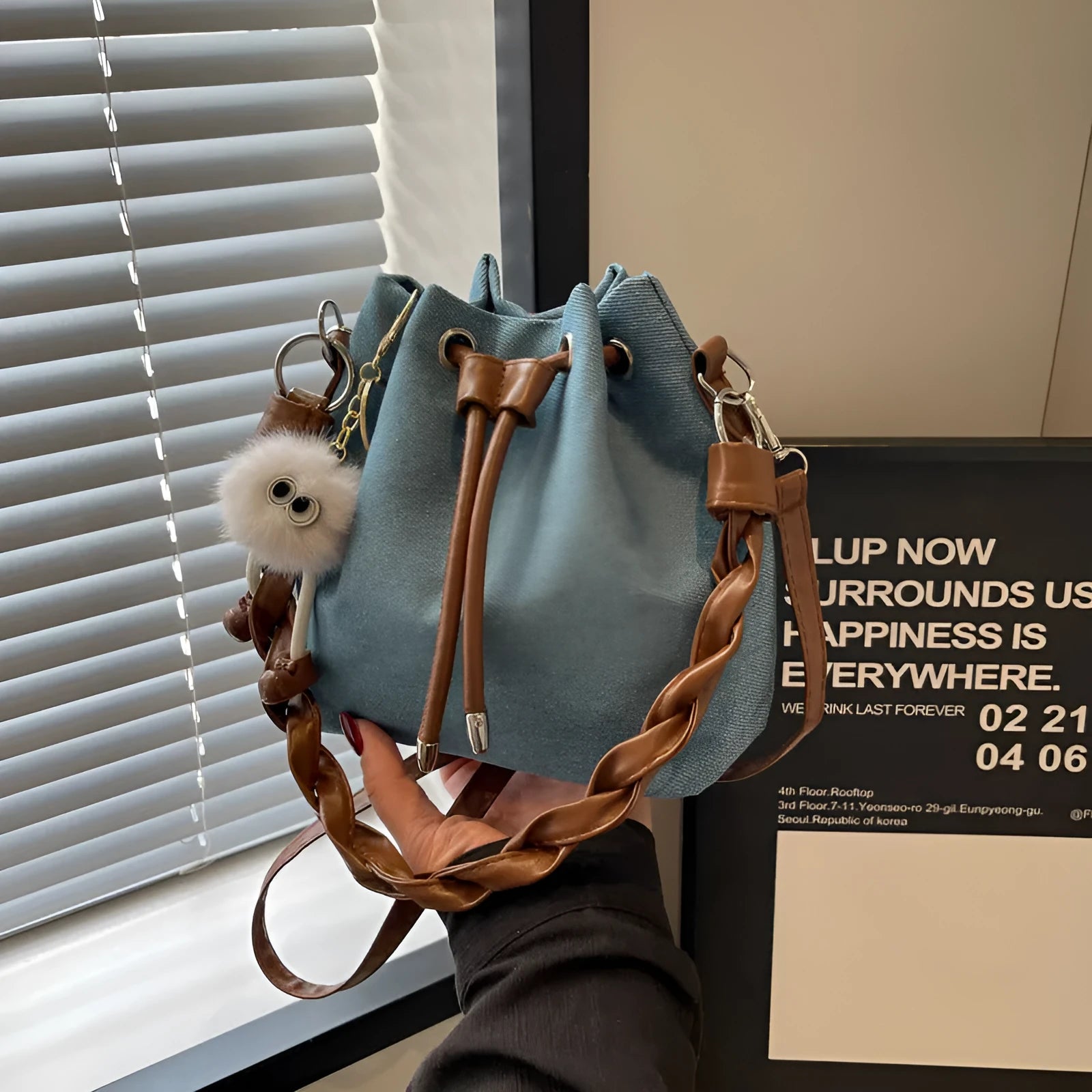 Blue one-shoulder cross body bucket bag with sandwich pocket and synthetic leather lining