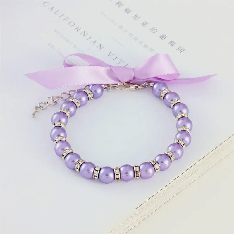 Adjustable dog necklace with imitation pearls, rhinestones, and ribbon bow for small pets