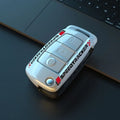 Carbon fibre style car key cover with a small mirror, shown in black and white colour options.