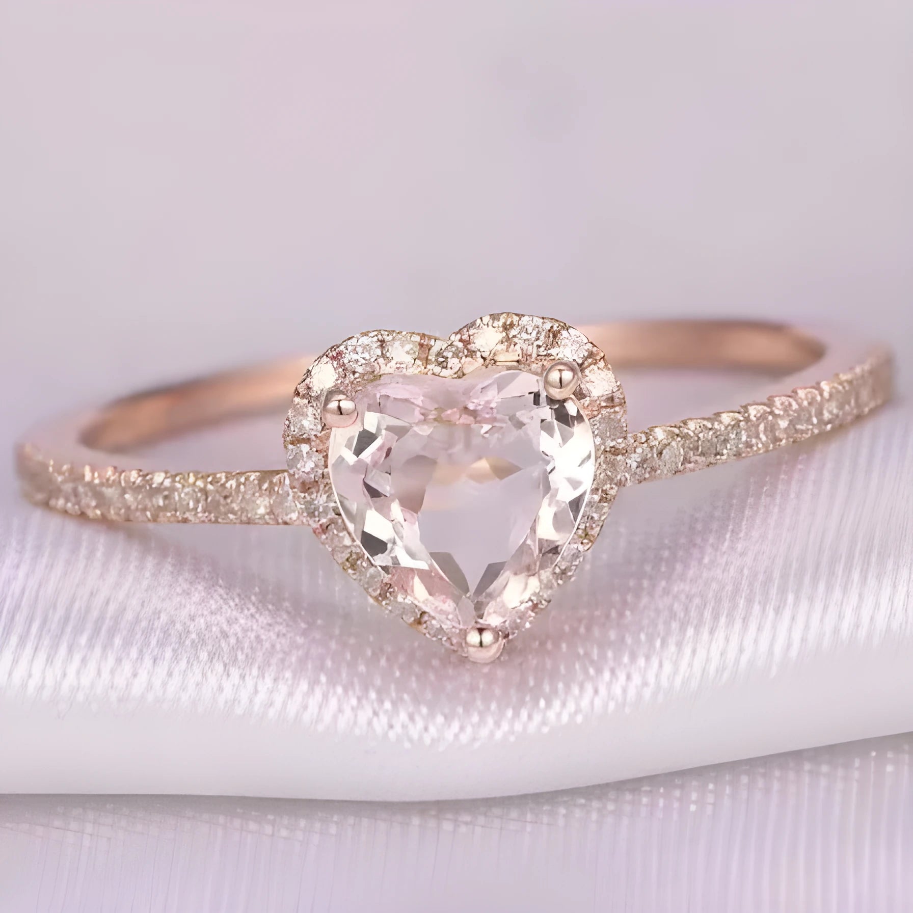 Women's fashion crystal heart-shaped ring in rose gold or silvery on a white background.