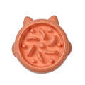 Green bone-ridge slow feeder bowl for dogs and cats on a floor.