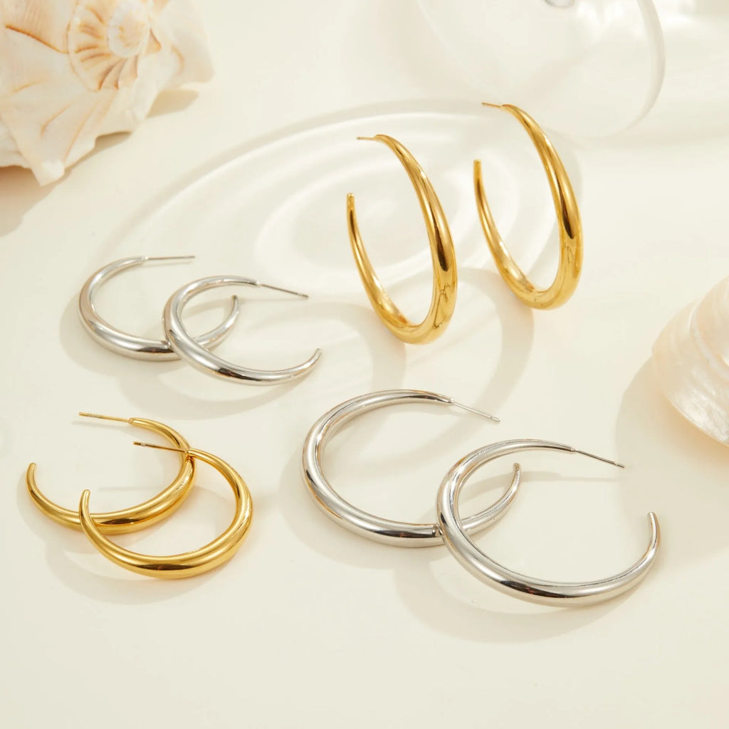 Simple round titanium steel hoop earrings for women in gold and steel finishes, shown in large and small sizes.