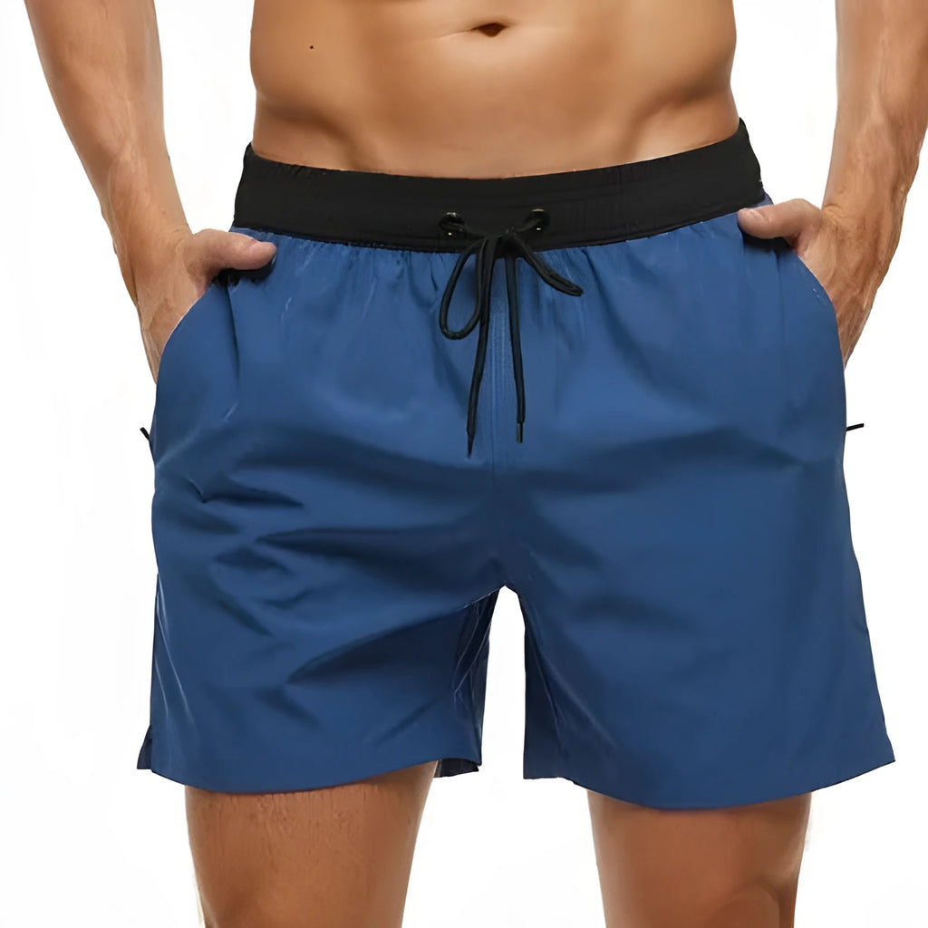 Men's blue athletic shorts with stitching waist detail and zipper pockets for running and fitness