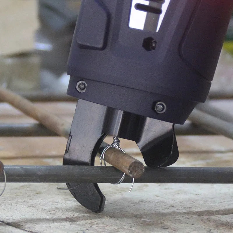 Fully automatic electric steel bar tying machine with battery and charger on a construction site.