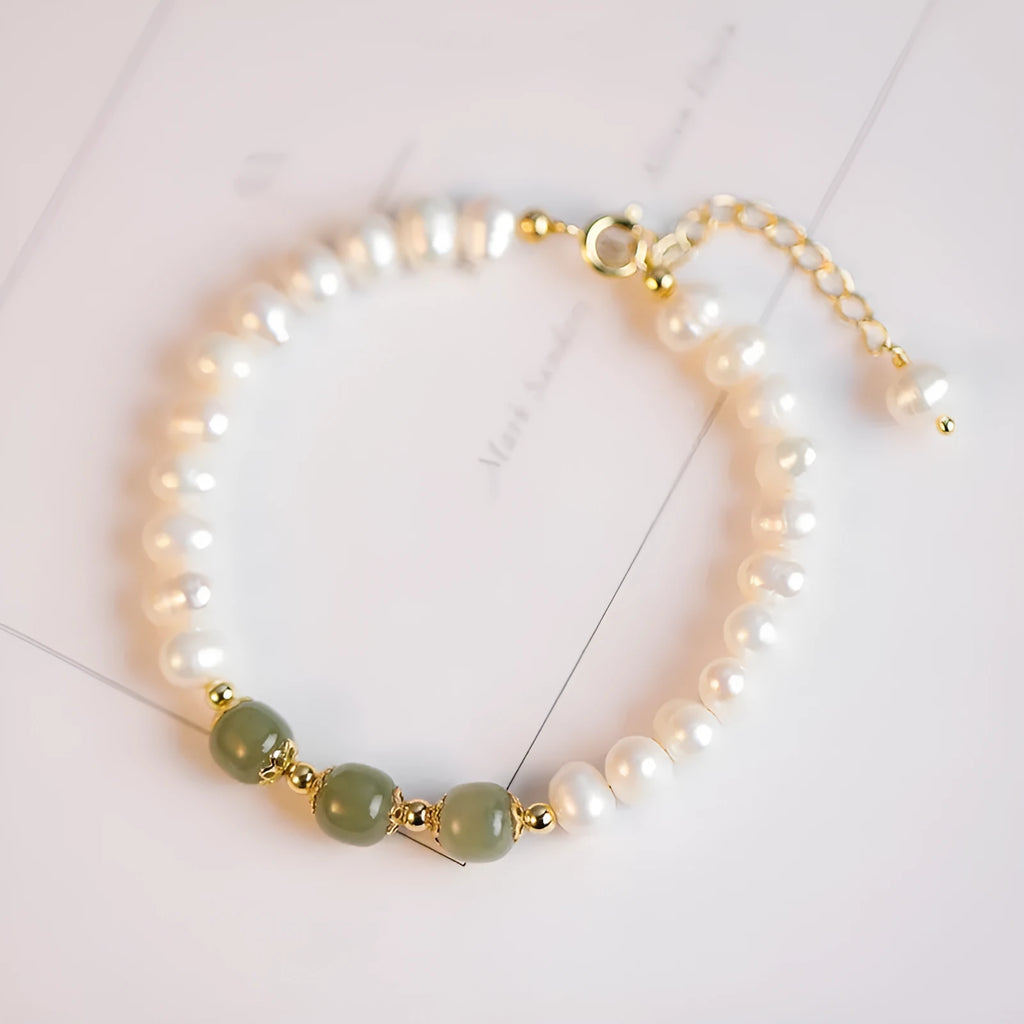 Close-up of a diamond-shaped freshwater pearl bracelet in an electroplated Hetian jade colour on a wrist.
