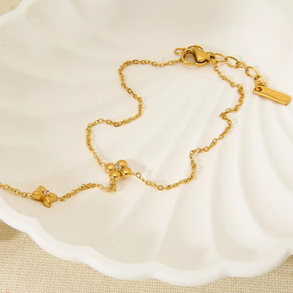 Gold-coloured stainless steel women's bracelet with eight-pointed star and floral charm design