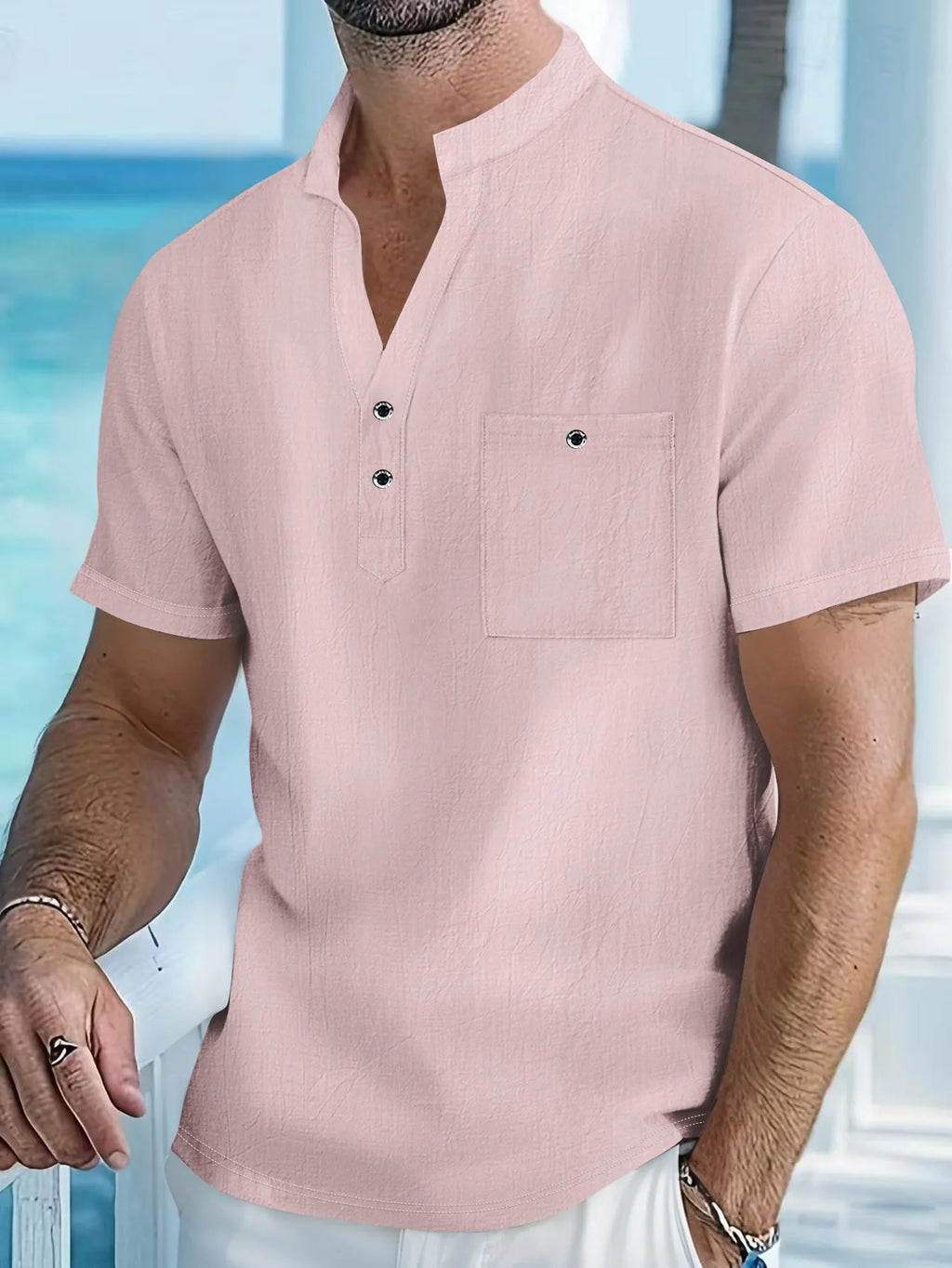 Man wearing a light apricot-coloured linen short sleeve shirt with a stand collar.