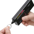 Black second generation diamond thermal conductivity tester with metal probe, shown with scale.