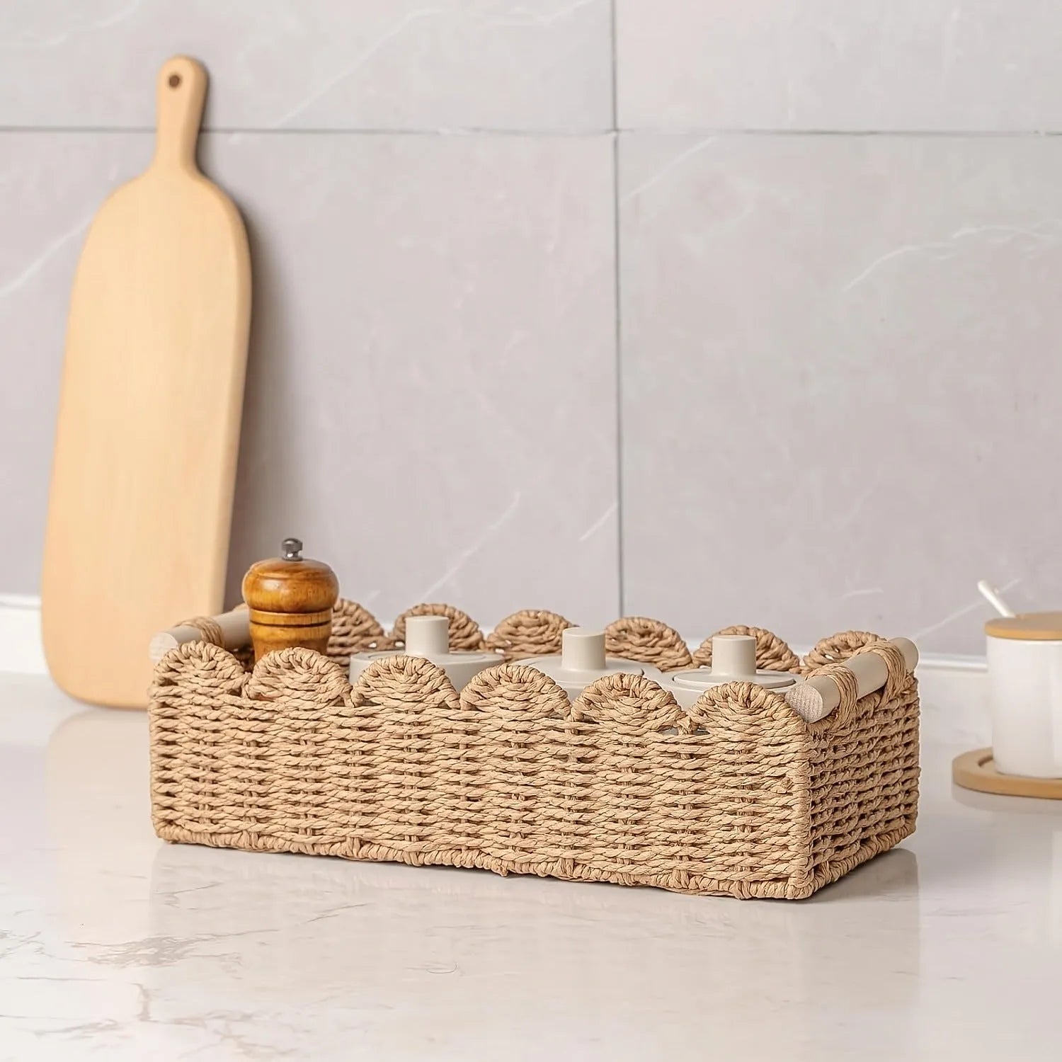 Rectangular woven paper storage basket in a neutral colour on a wooden desktop