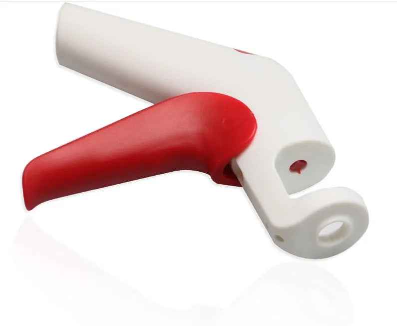 Close-up of a manual cherry pitter tool showing plastic handle and stainless steel mechanism.