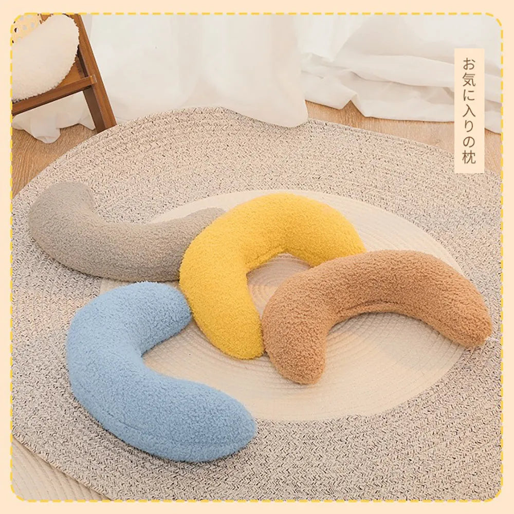 Blue U-shaped cat pillow with an adjustable fabric collar for neck support on a grey sofa