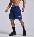 Men's loose grey cropped sports shorts with letter detailing and an elastic fly opening.