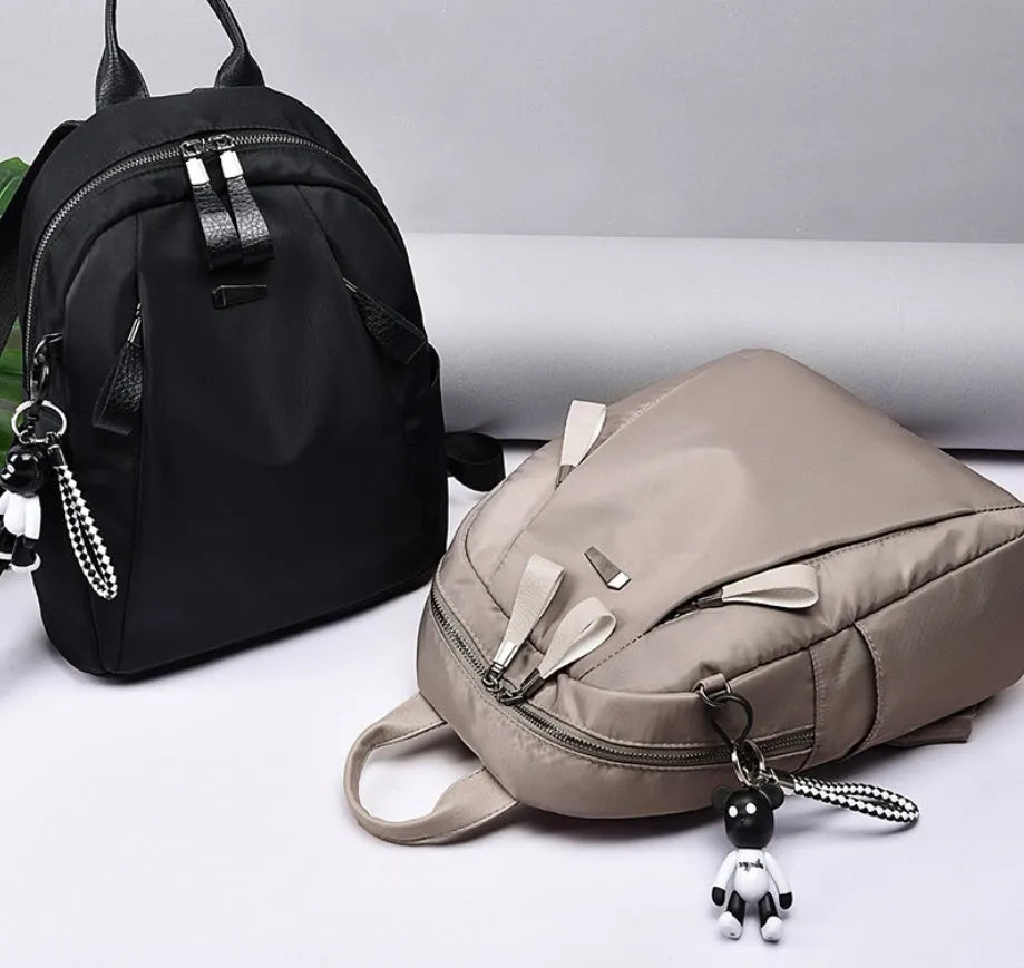 Medium-sized wine red Oxford cloth rucksack with double shoulder straps and a front digging bag.