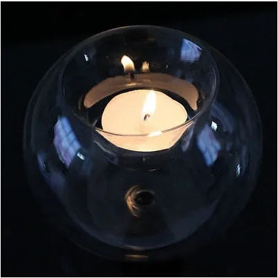Handmade clear hollow glass spherical candle holder in European style on a table.