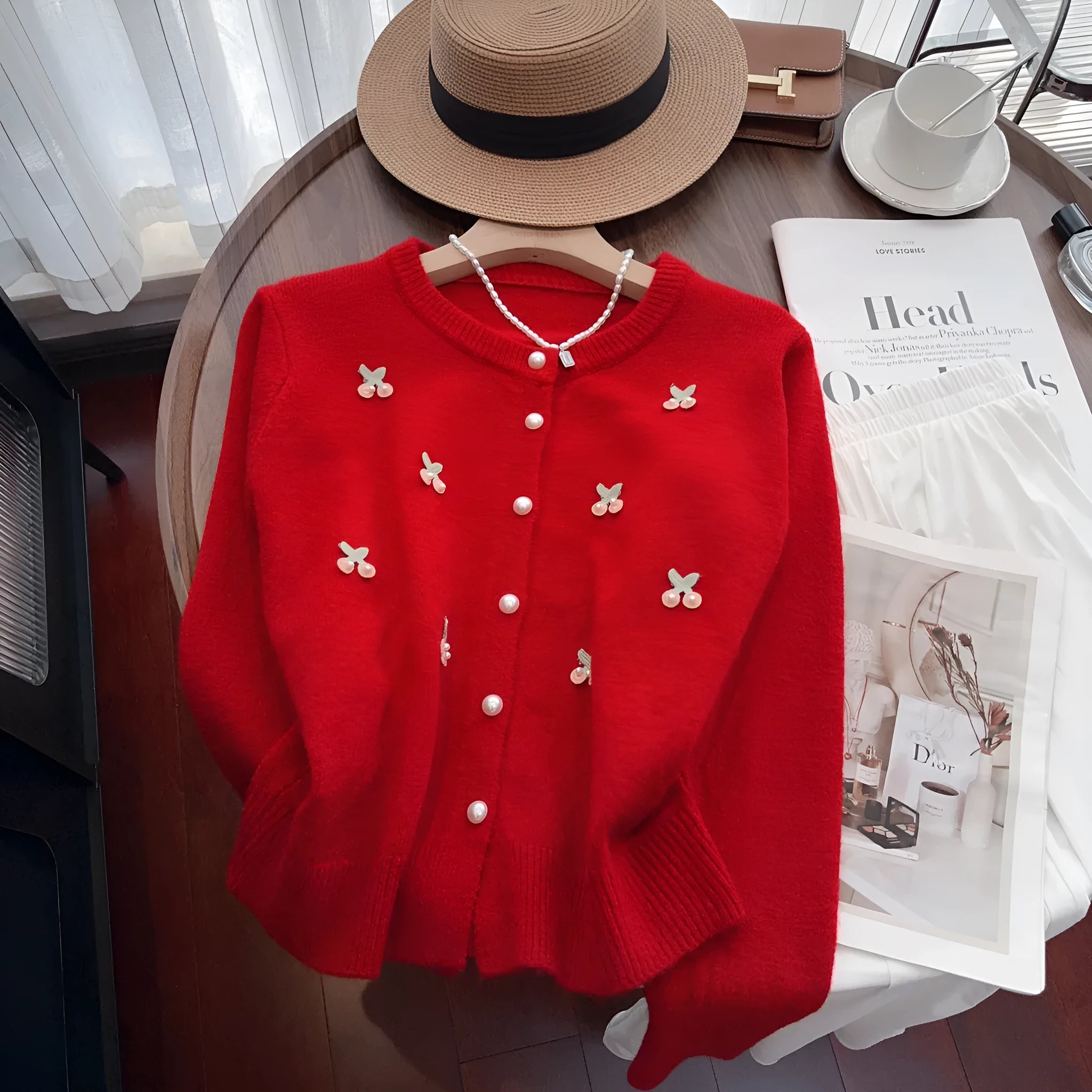Women's slim fit cashmere cardigan with bead details on hanger, showing gentle round neckline in pink colour.