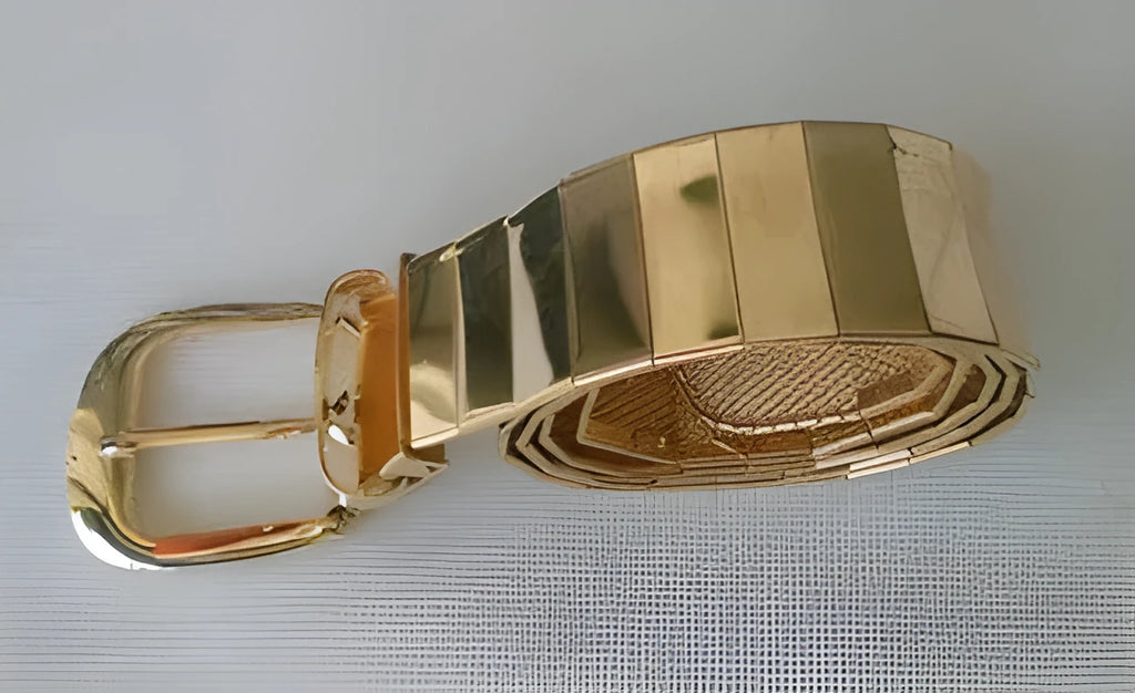 Three shiny belts in gold, silver, and black metallic finish arranged together
