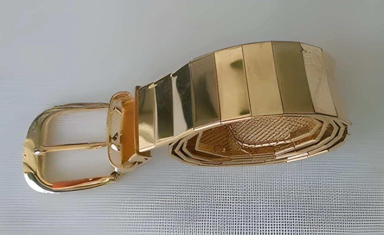Three shiny belts in gold, silver, and black metallic finish arranged together