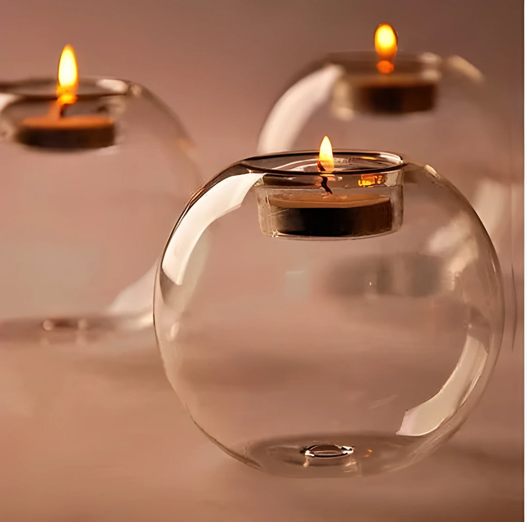 Handmade clear hollow glass spherical candle holder in European style on a table.