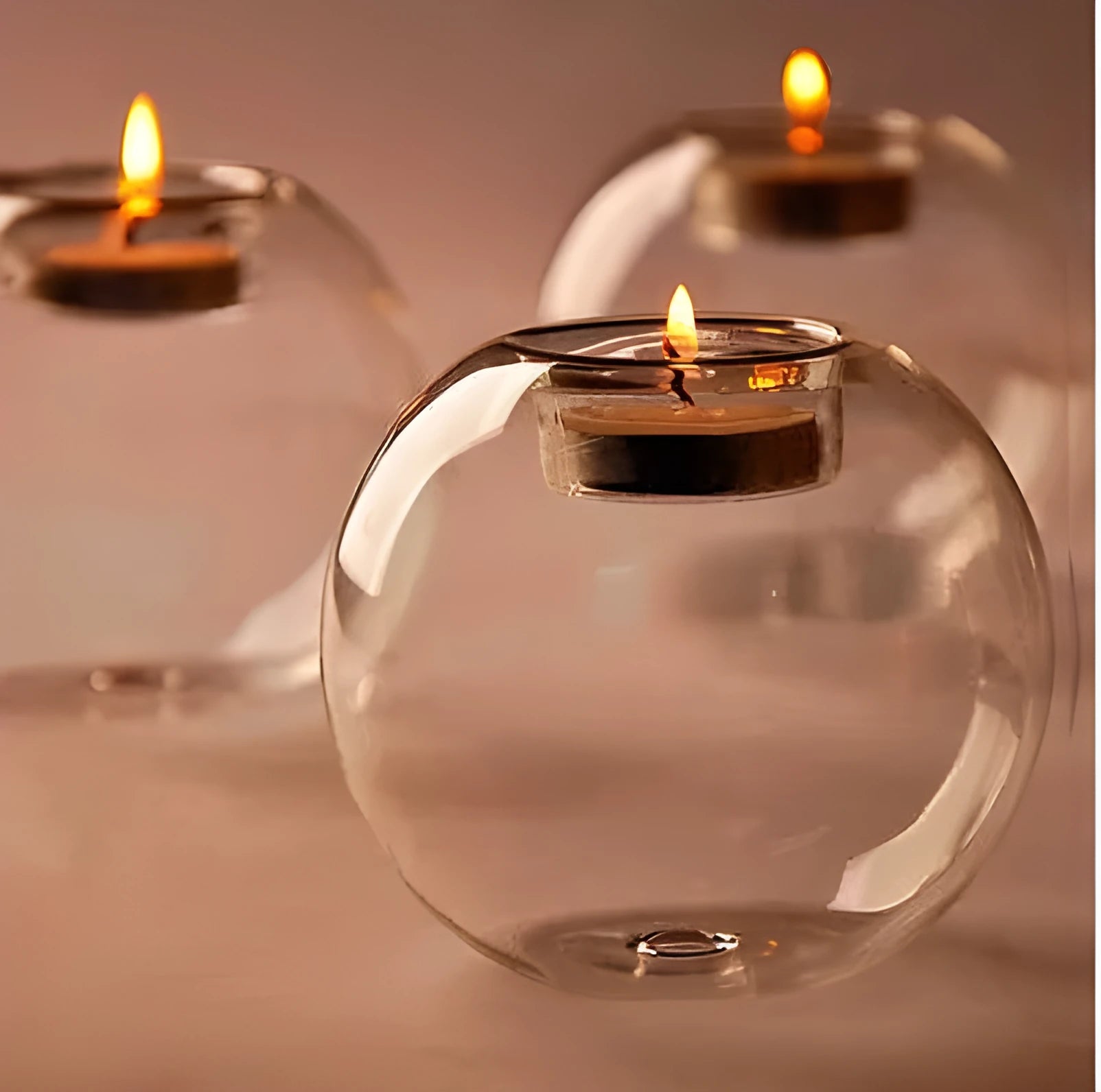 Handmade clear hollow glass spherical candle holder in European style on a table.