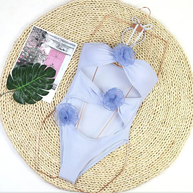 Women's nylon one-piece swimsuit with 3D flower detail in black or blue stripes colours
