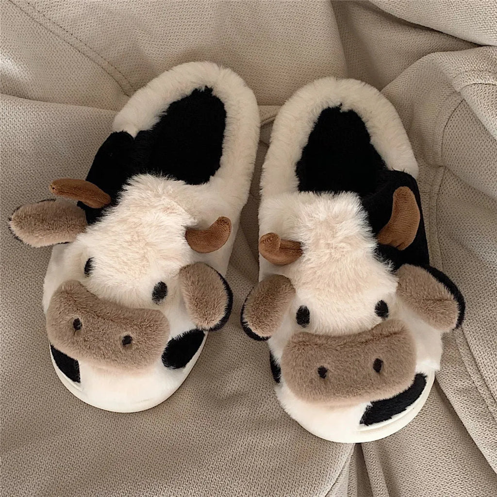 White plush cow-themed house slippers for women with a non-slip textured sole.
