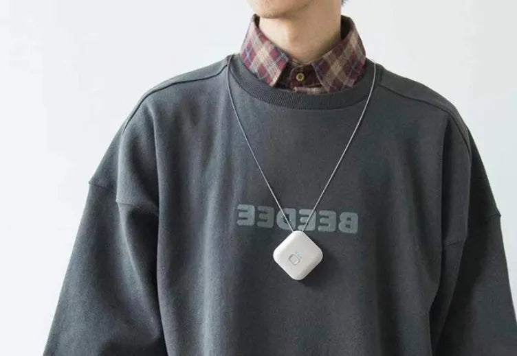 Mini USB portable air purifier necklace in pink, showing compact design with single button.