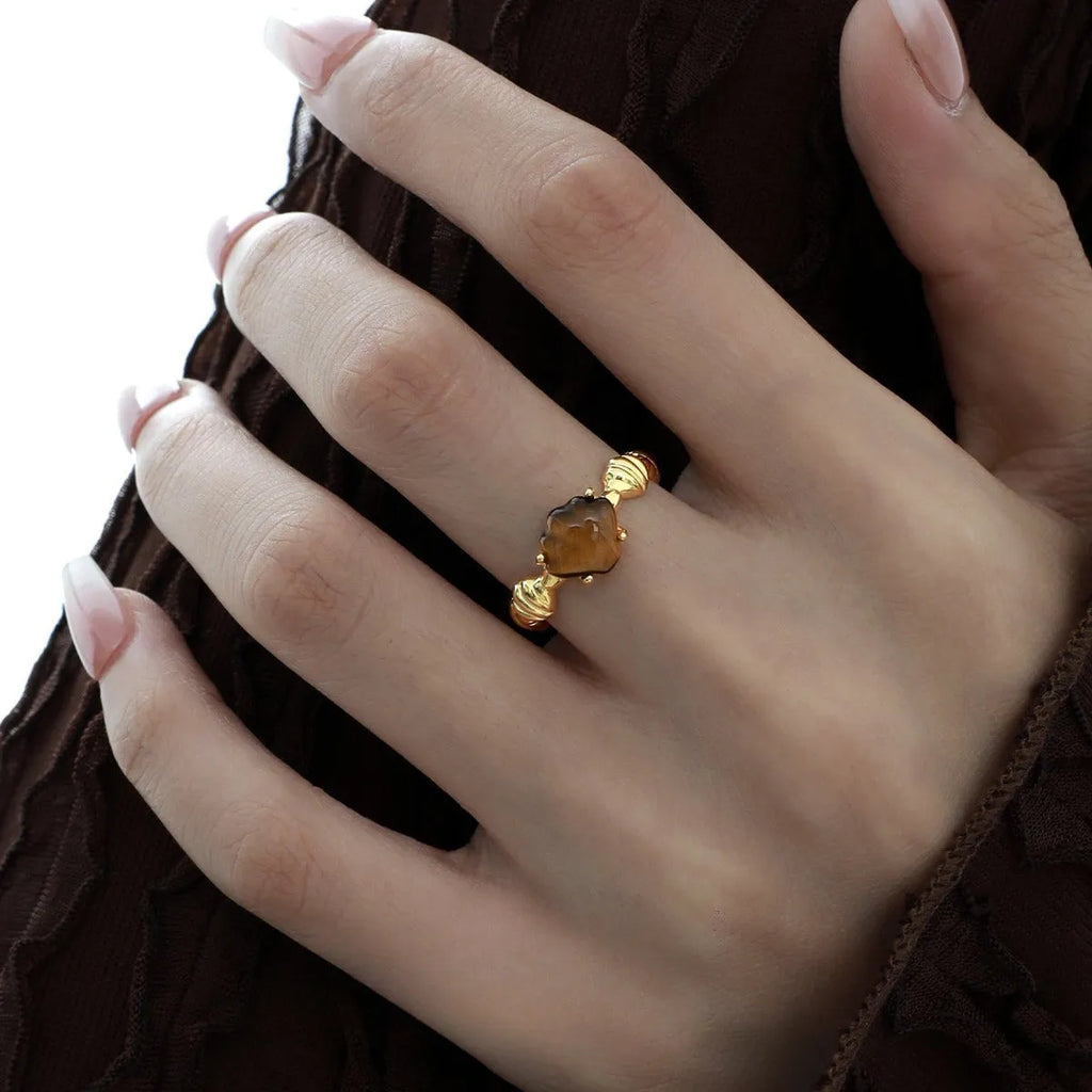 Women's sterling silver ring with shell element, tiger eye accents, and adjustable opening in gold electroplated finish