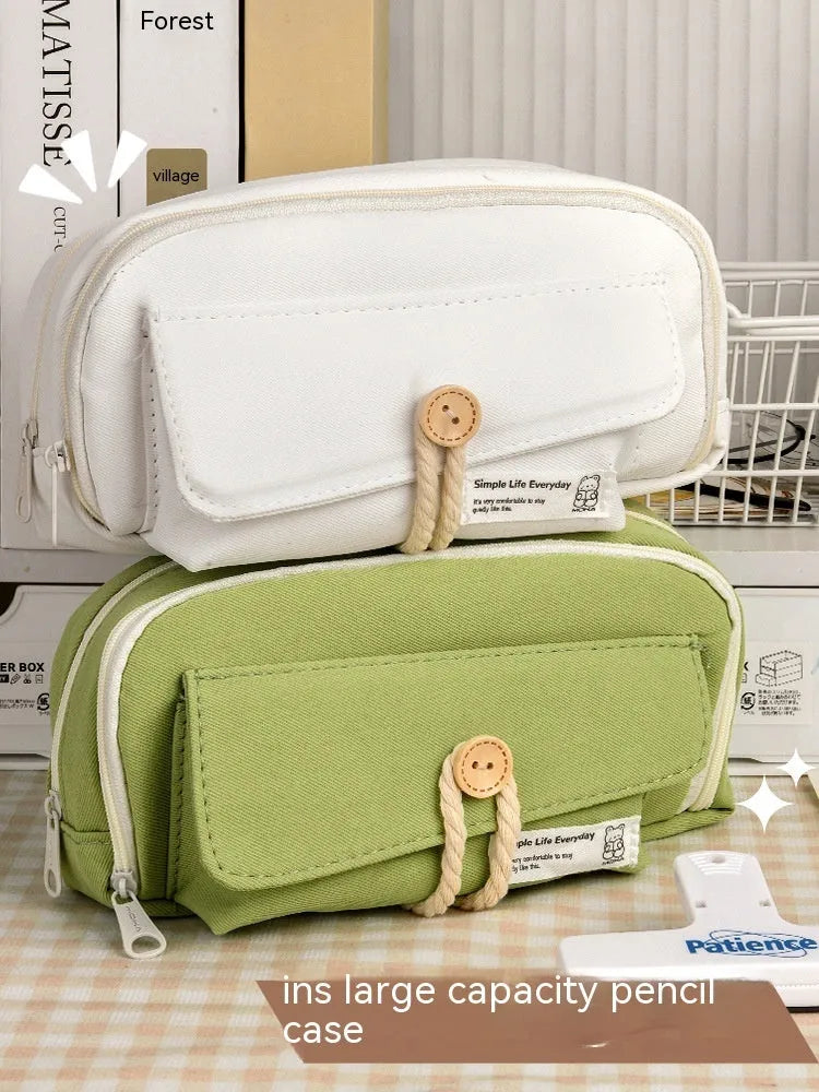 Korean style canvas pencil case in beige, blue, grey, or green holding multiple pens