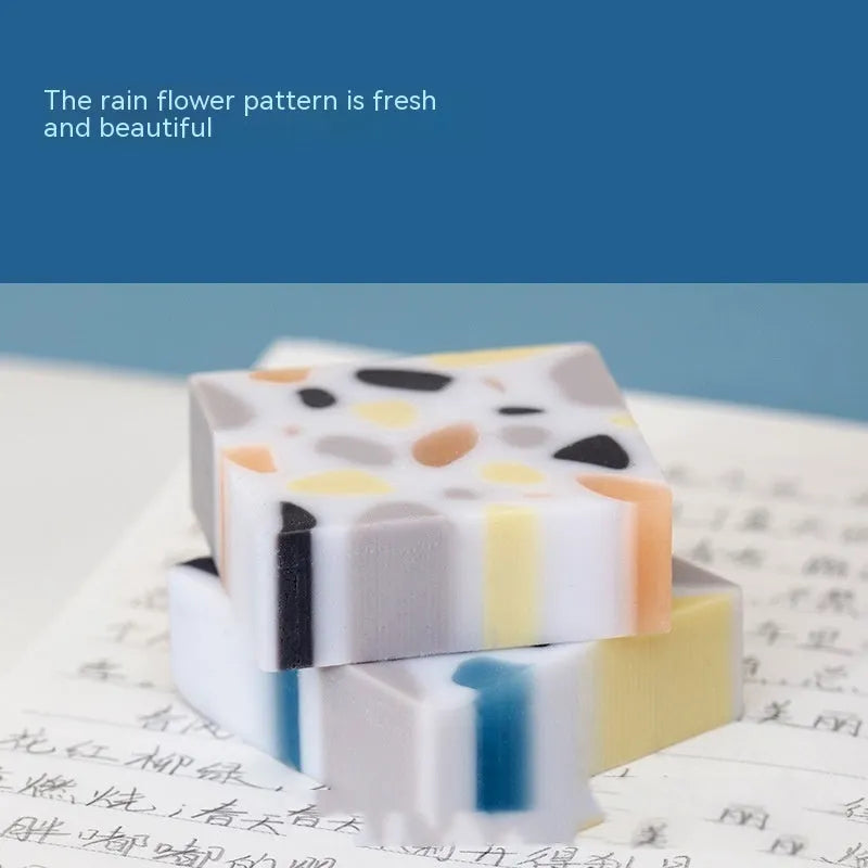A single white rubber eraser in a brick shape with straight edges, for cleaning pencil marks from paper.